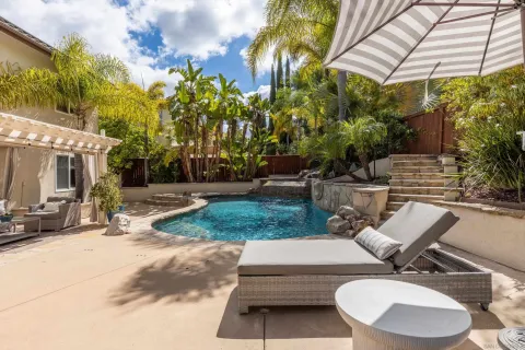 a view of backyard with swimming pool and sitting area