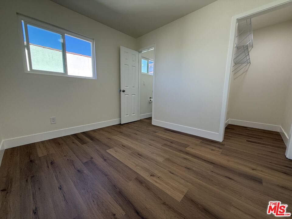 1716 Locust Avenue, Unit 5 Long Beach, CA 90813 - Photo 5 of 7 a view of an empty room with wooden floor and a window