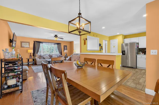 a kitchen with stainless steel appliances granite countertop a refrigerator a stove and a sink with wooden floor