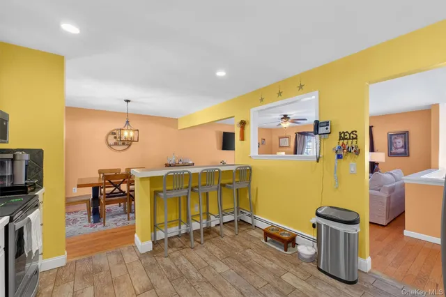 a kitchen with stainless steel appliances a stove a sink cabinets and a dining table