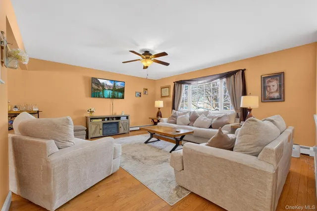 a living room with furniture wooden floor and a window