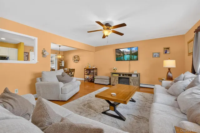 a view of a dining room and livingroom with furniture wooden floor a chandelier