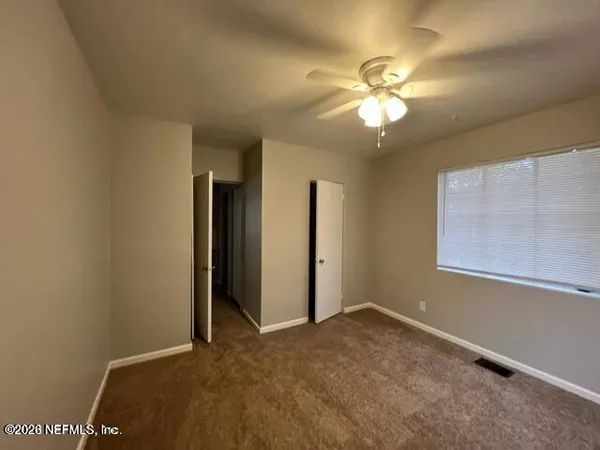 a view of a livingroom with a ceiling fan and window
