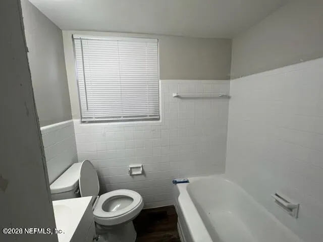 a white toilet sitting next to a bath tub