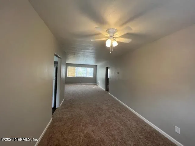 en empty room with windows and fan