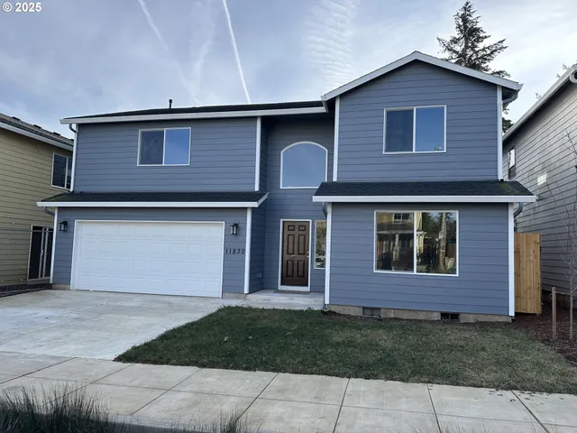 a front view of a house with a yard and garage