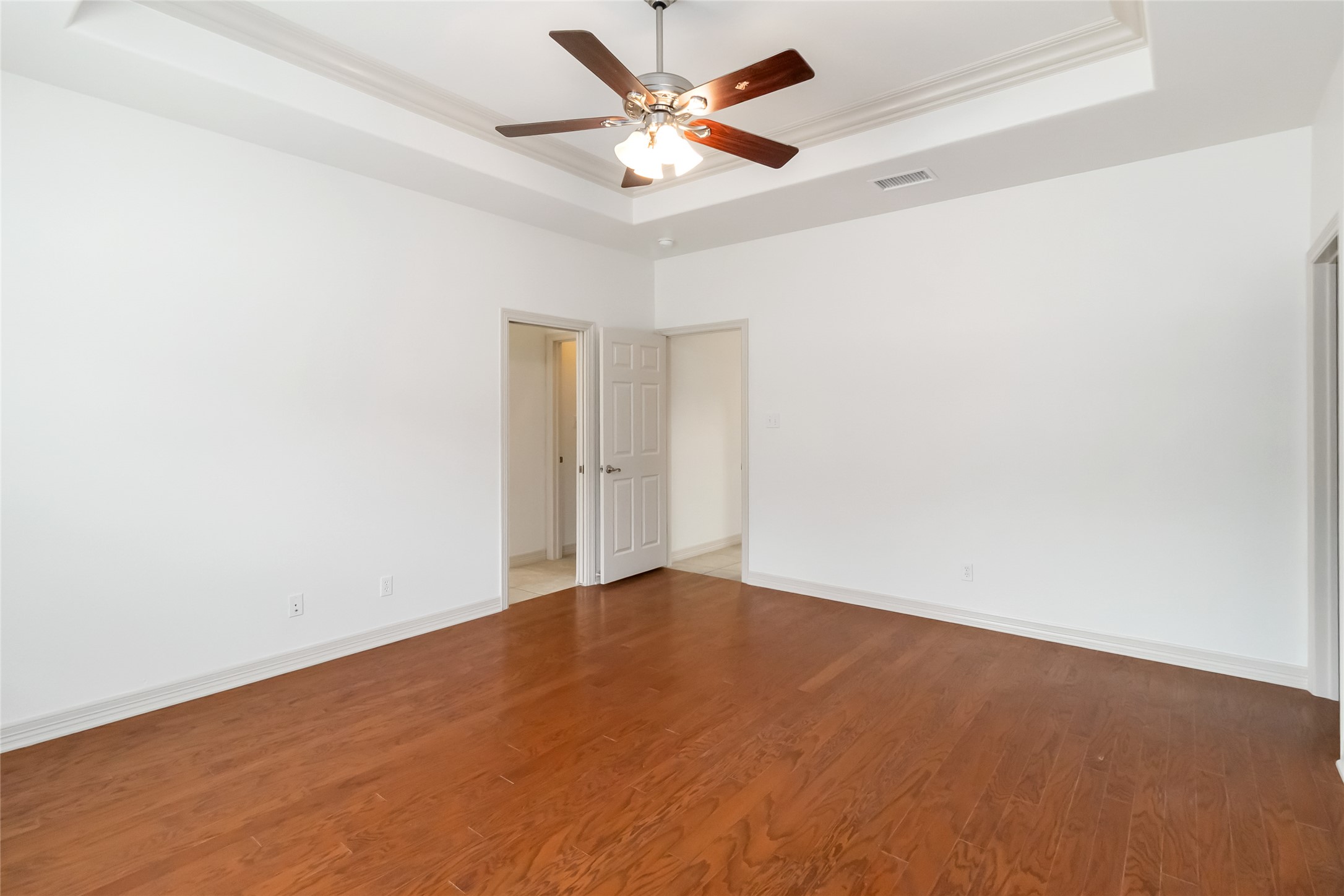 167 Winchester Road Bastrop, TX 78602 - Photo 19 of 34 Spare room featuring a tray ceiling, wood finished floors, a ceiling fan, and crown molding