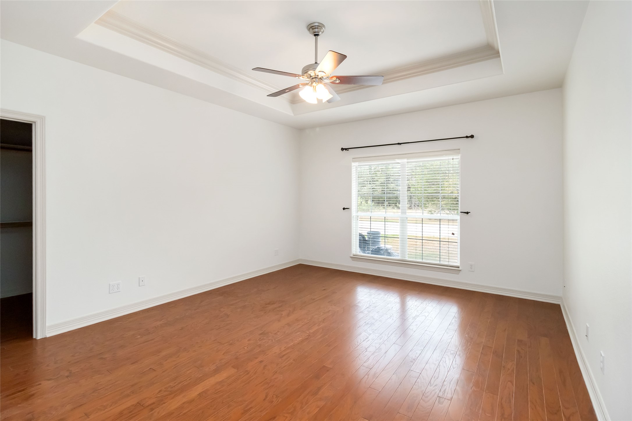 167 Winchester Road Bastrop, TX 78602 - Photo 20 of 34 Spare room featuring a tray ceiling, wood finished floors, and ceiling fan