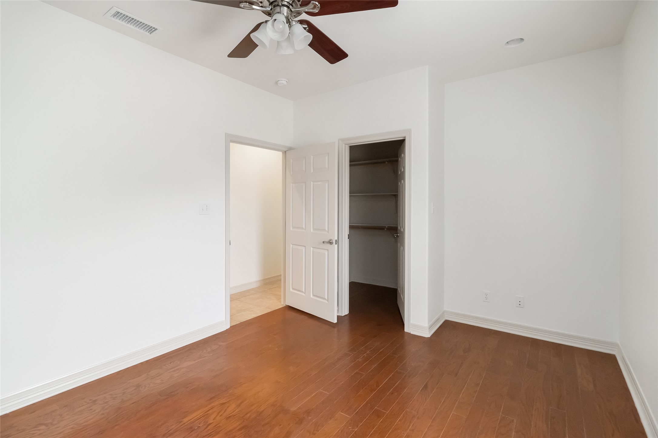 167 Winchester Road Bastrop, TX 78602 - Photo 24 of 34 Unfurnished bedroom with a spacious closet, wood finished floors, and ceiling fan