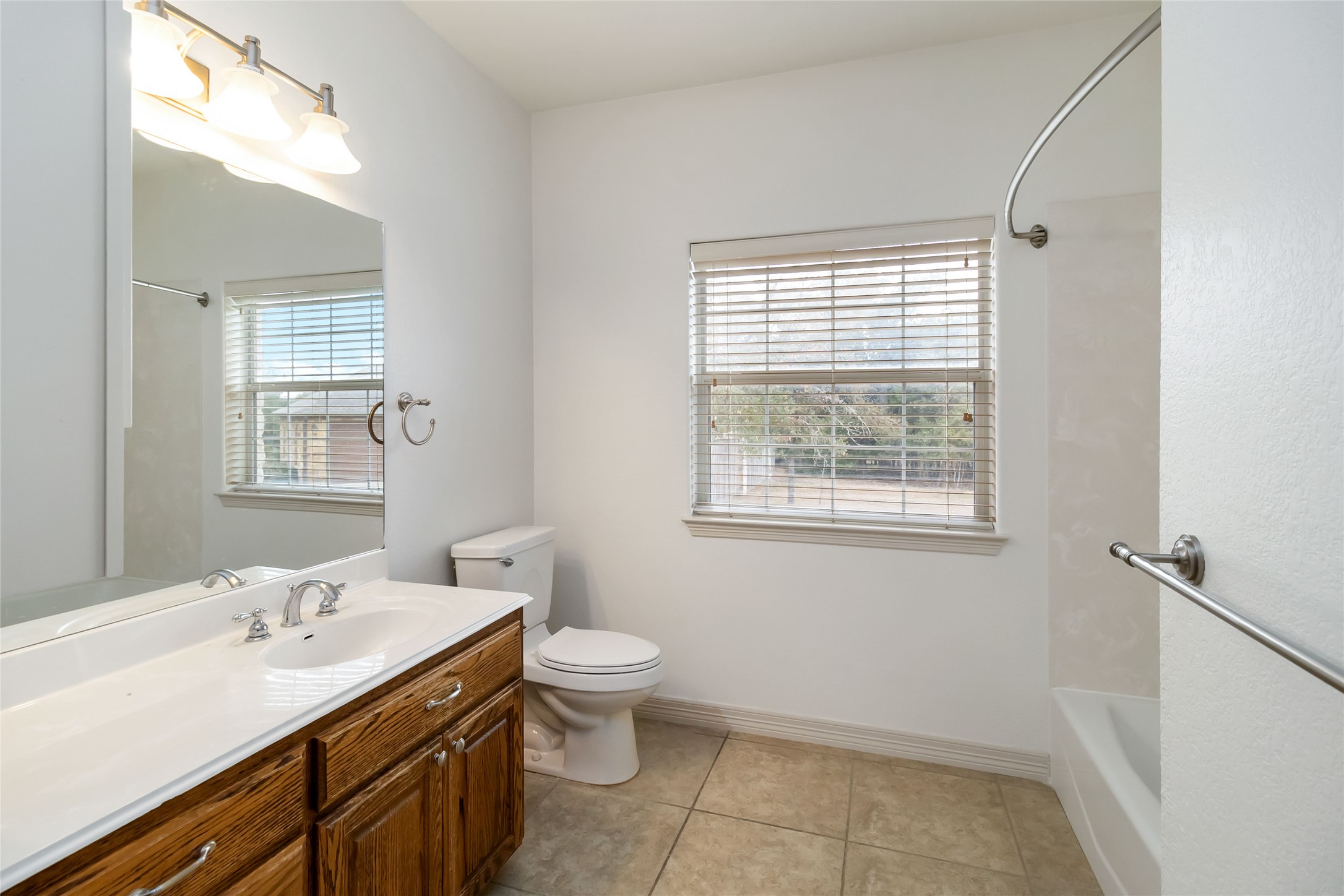 167 Winchester Road Bastrop, TX 78602 - Photo 28 of 34 Bathroom featuring vanity, plenty of natural light, light tile patterned floors, and shower / bath combination