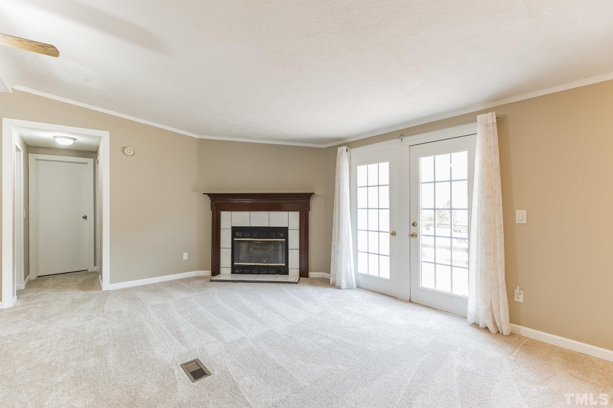 290 Thomas Cash Road Apex, NC 27523 - Photo 13 of 40 an empty room with windows and fireplace