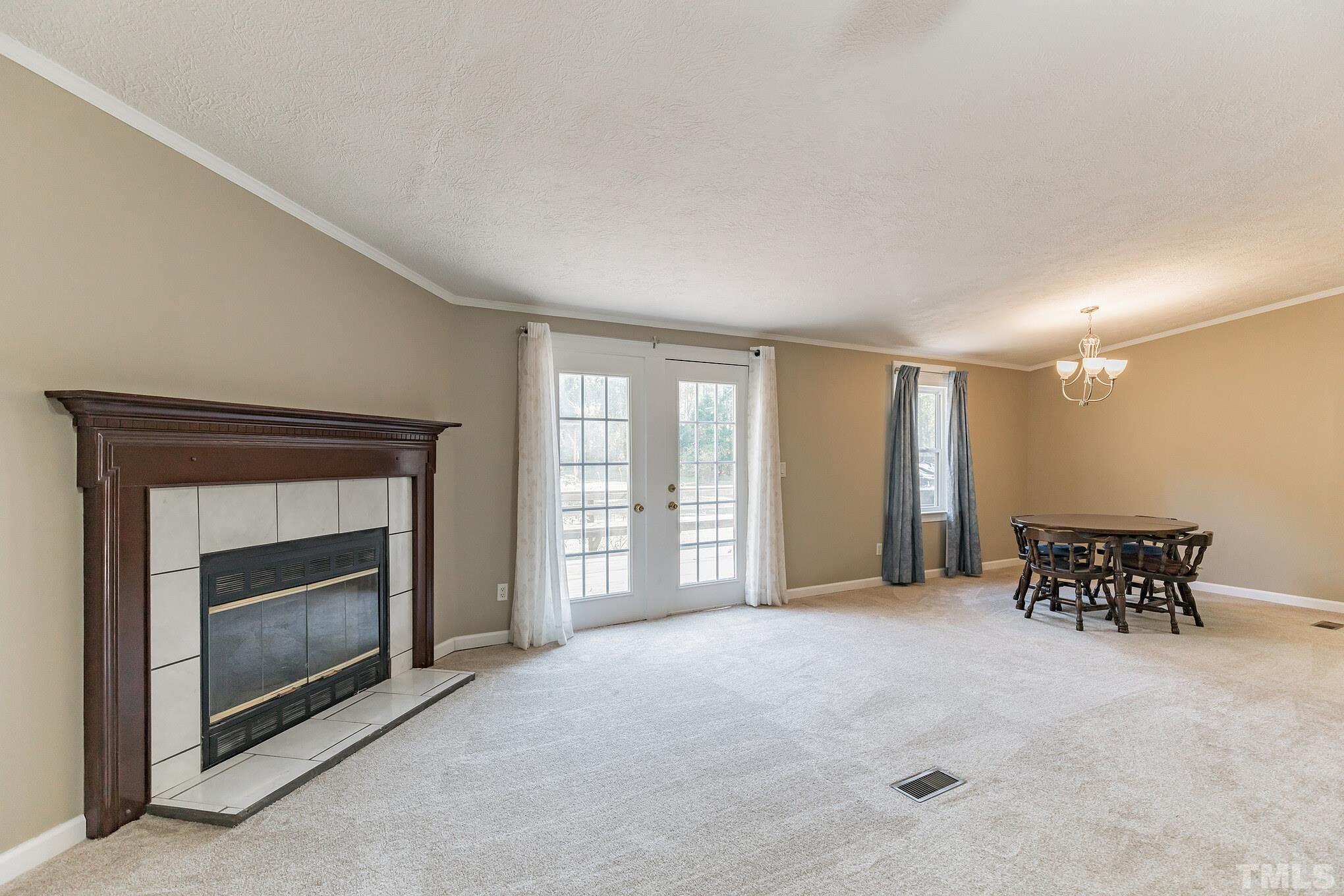 290 Thomas Cash Road Apex, NC 27523 - Photo 14 of 40 a view of an empty room with furniture and a fireplace