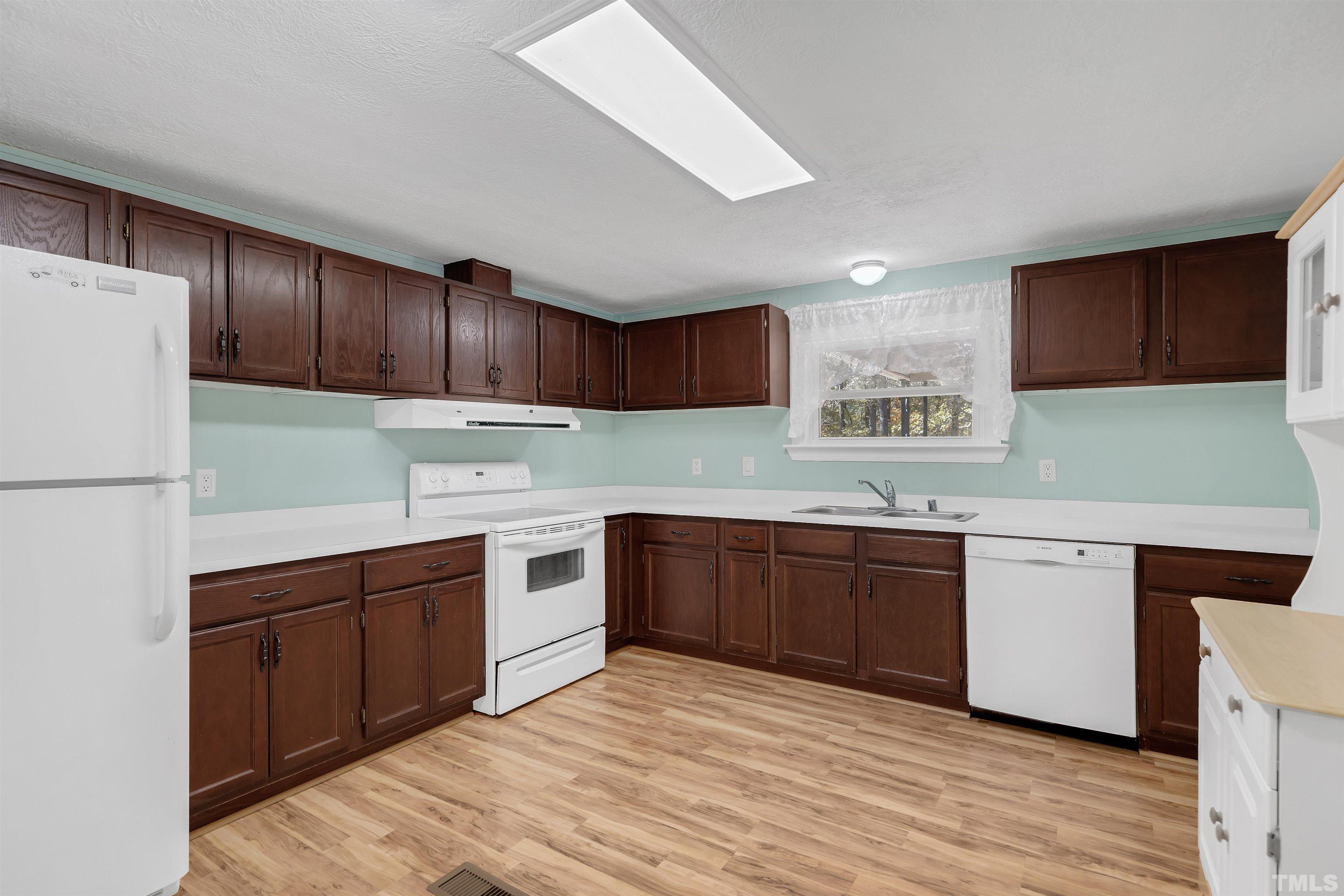 290 Thomas Cash Road Apex, NC 27523 - Photo 17 of 40 a kitchen with granite countertop a sink cabinets and stainless steel appliances