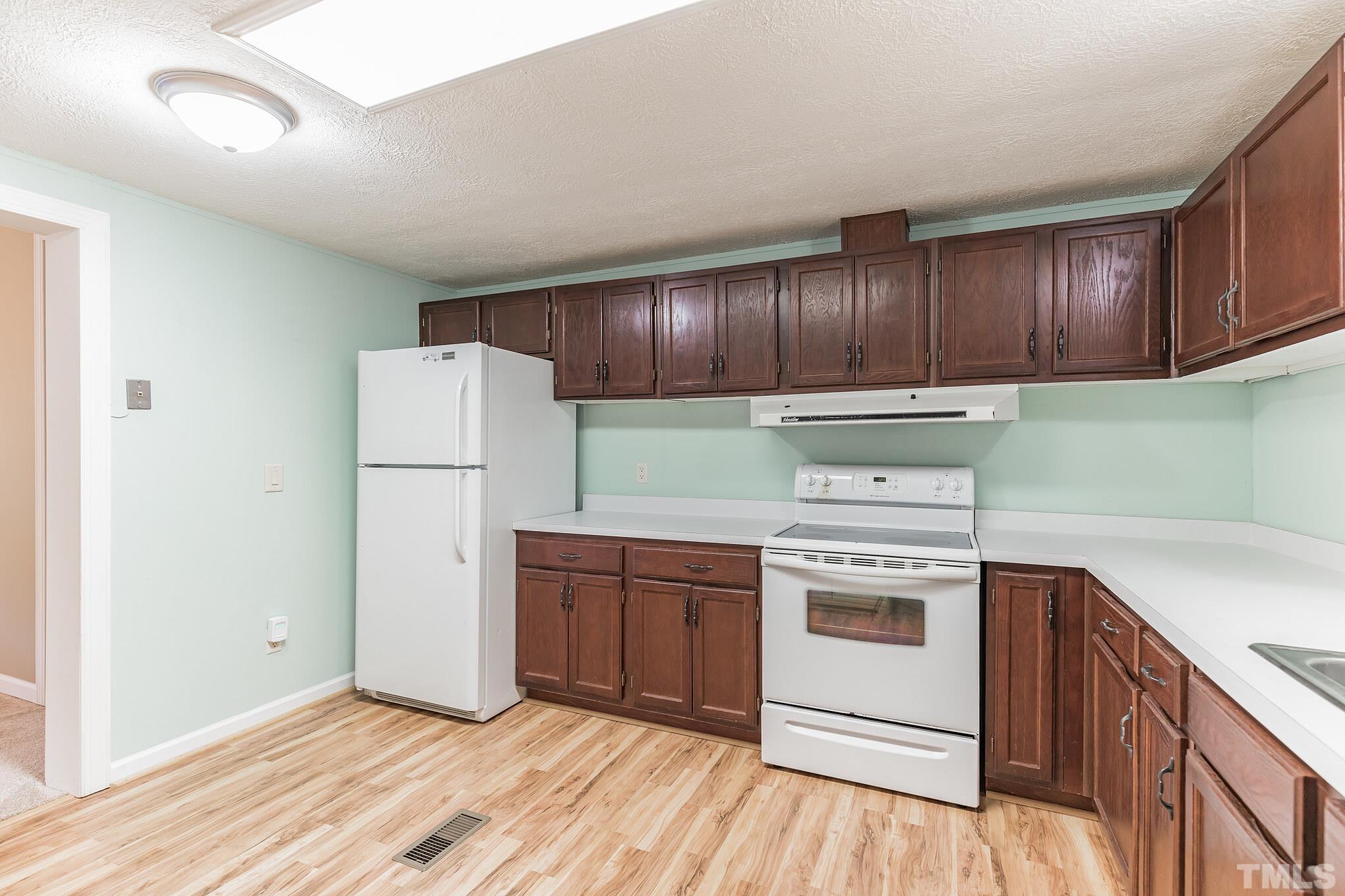 290 Thomas Cash Road Apex, NC 27523 - Photo 18 of 40 a kitchen with a white cabinets and white appliances