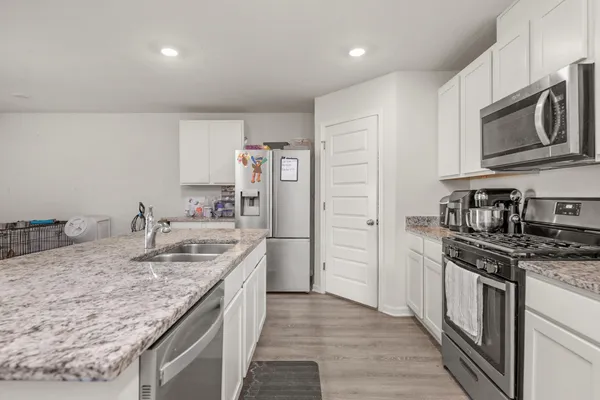 a kitchen with stainless steel appliances granite countertop a sink stove and refrigerator