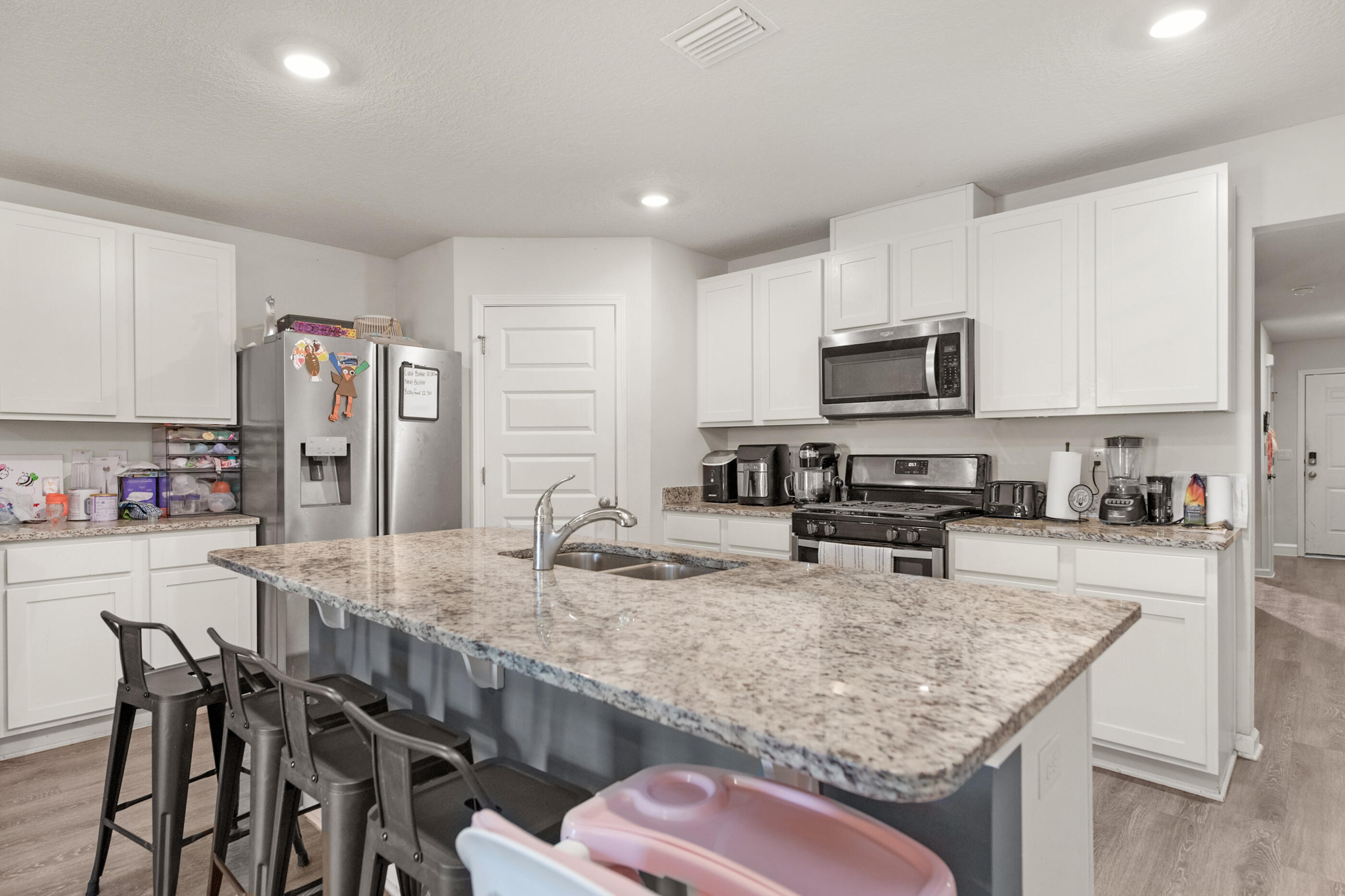 4662 Honor Guard Way Crestview, FL 32539 - Photo 4 of 10 a kitchen with stainless steel appliances granite countertop a sink dishwasher a stove refrigerator and microwave with wooden floor