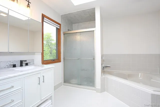 a bathroom with a bathtub sink and window