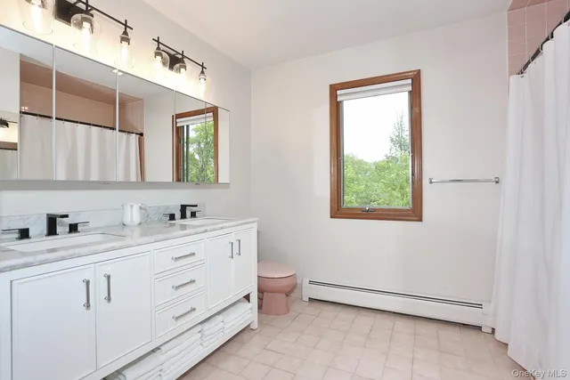 a bathroom with a toilet sink and mirror