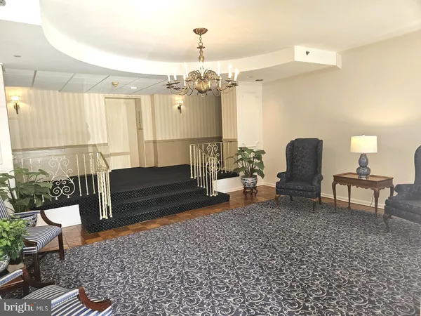a living room with furniture and a chandelier