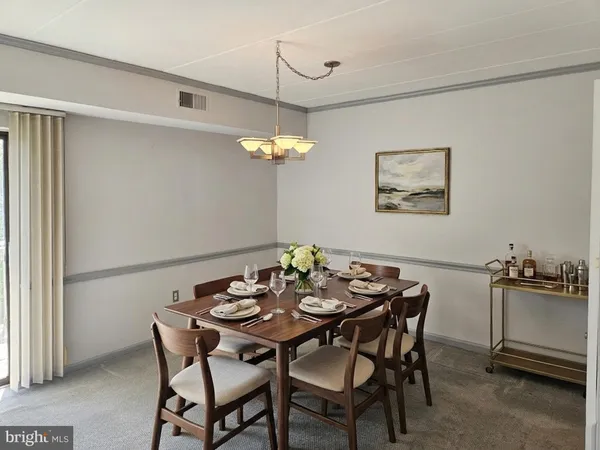 a view of a dining room with furniture and chandelier