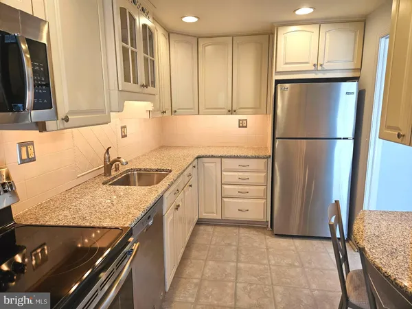 a kitchen with stainless steel appliances granite countertop a refrigerator and a sink