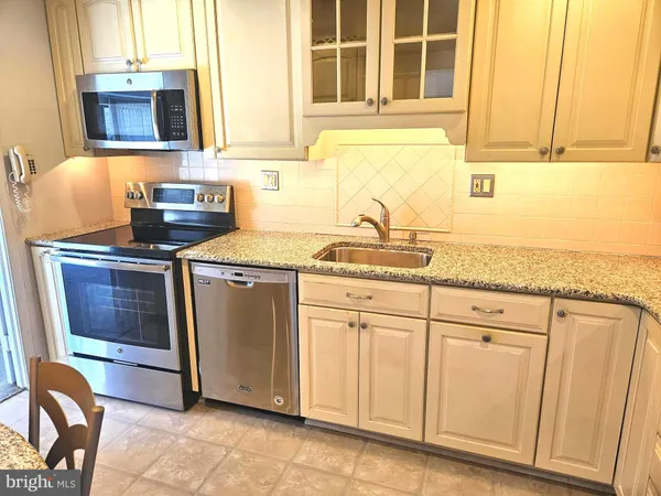 a kitchen with granite countertop cabinets stainless steel appliances and a sink