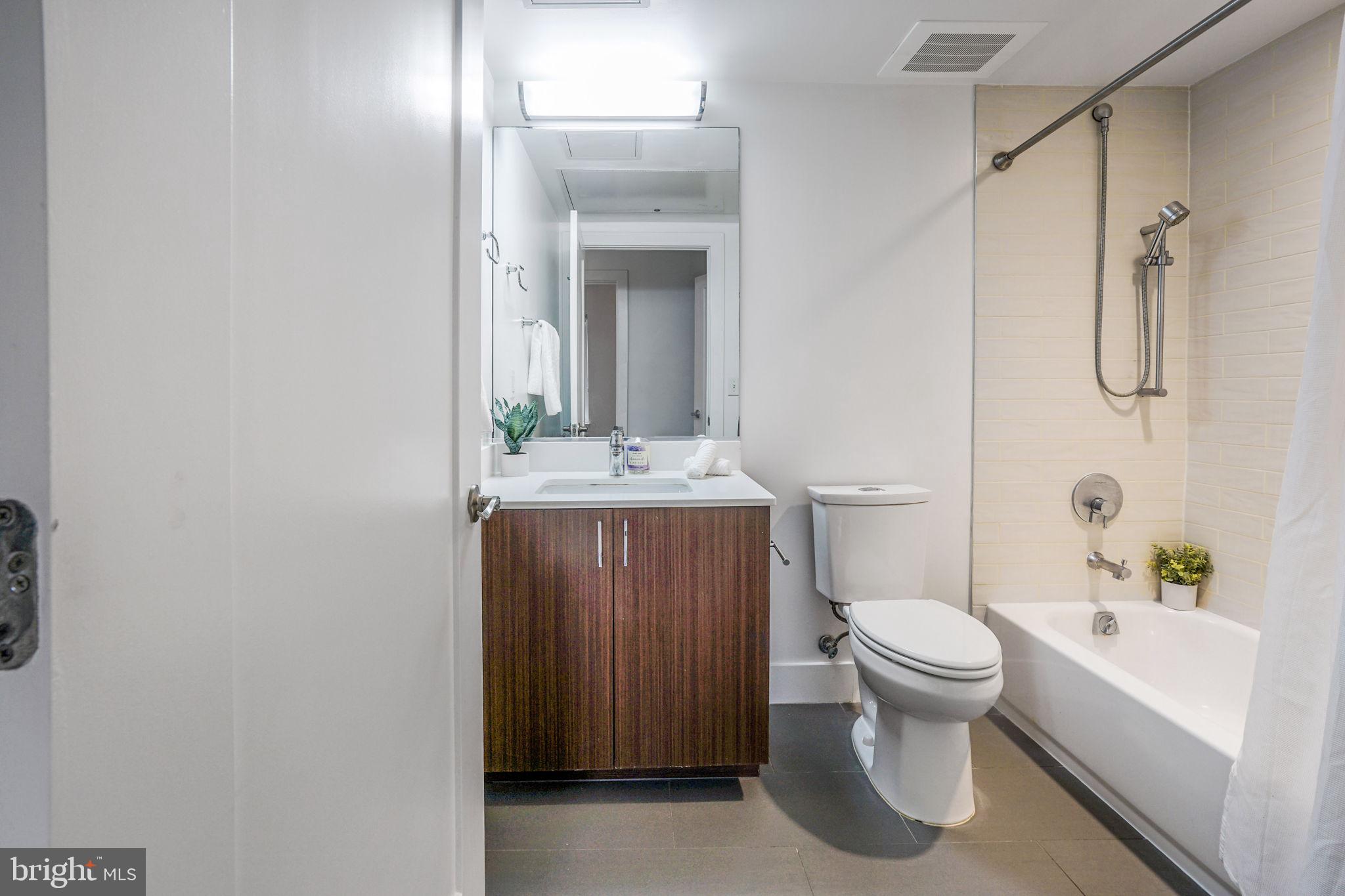 1111 Orren Street Northeast, Unit 310 Washington, DC 20002 - Photo 11 of 26 a bathroom with a sink a toilet and shower
