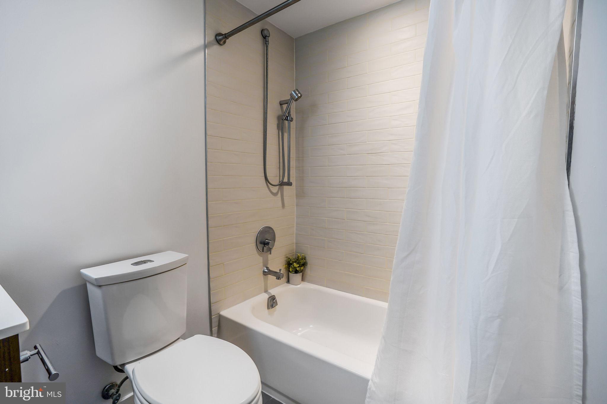 1111 Orren Street Northeast, Unit 310 Washington, DC 20002 - Photo 13 of 26 a white toilet sitting next to a bath tub