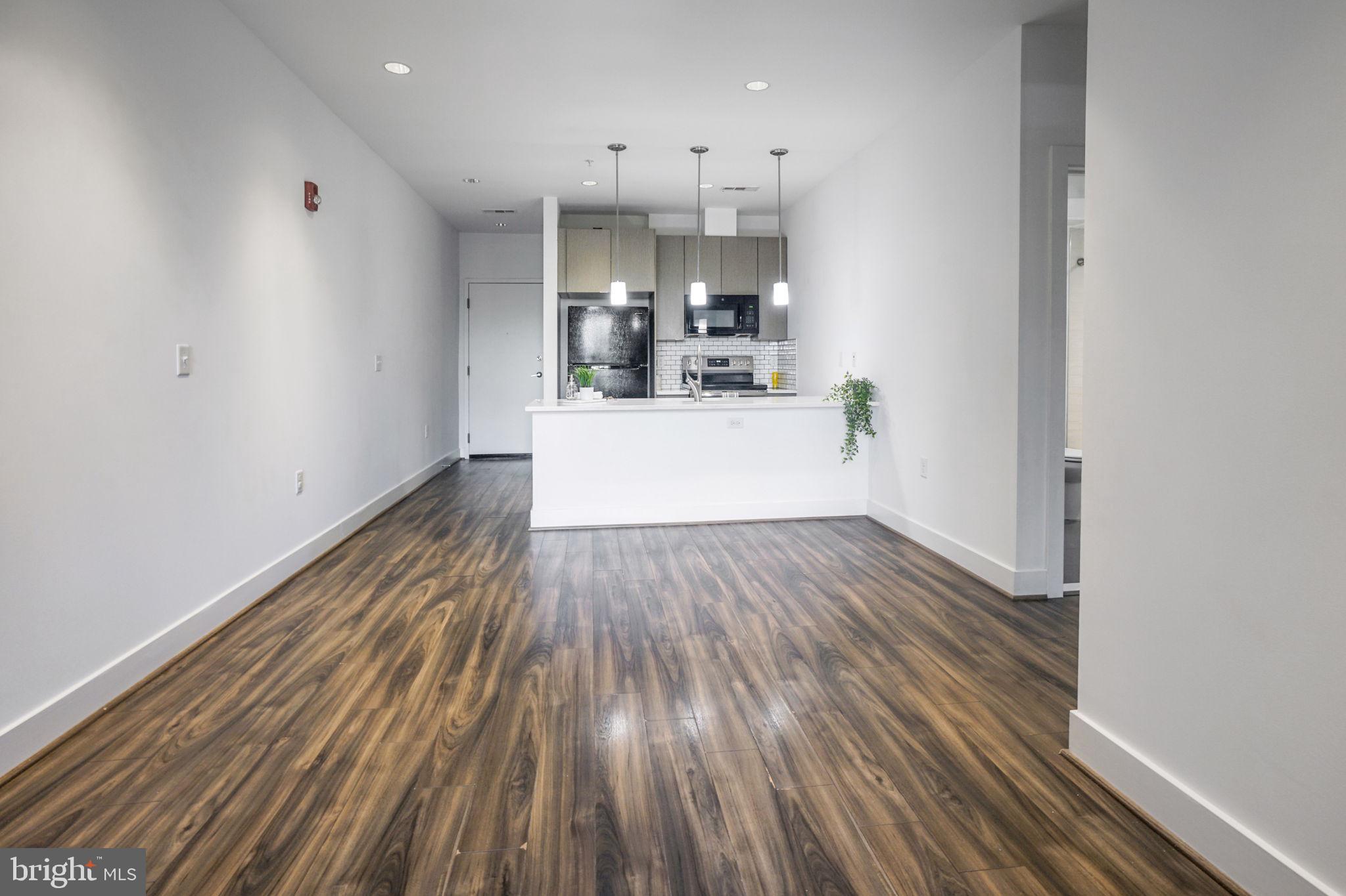 1111 Orren Street Northeast, Unit 310 Washington, DC 20002 - Photo 4 of 26 a view of a kitchen with wooden floor