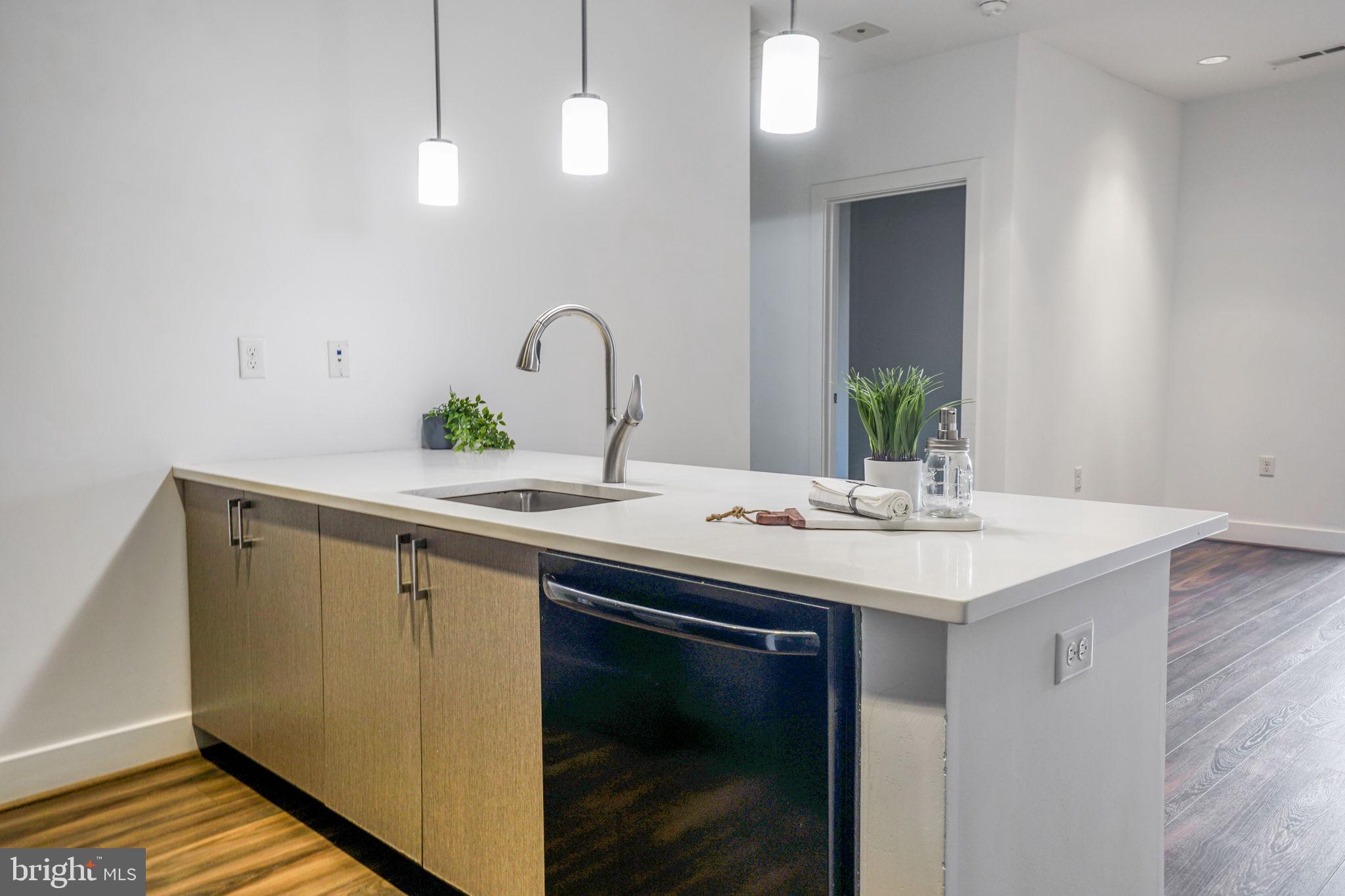 1111 Orren Street Northeast, Unit 310 Washington, DC 20002 - Photo 6 of 26 a kitchen with a sink and a refrigerator