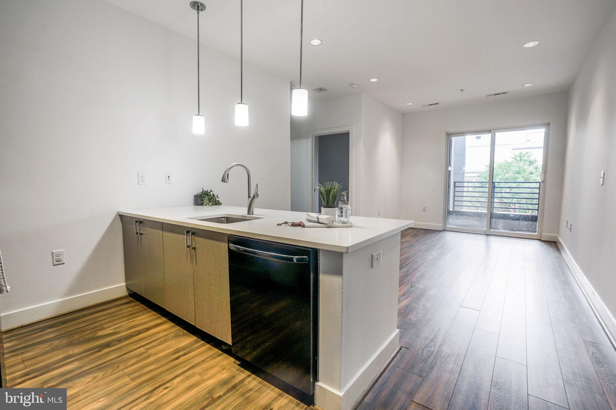 1111 Orren Street Northeast, Unit 310 Washington, DC 20002 - Photo 7 of 26 a kitchen with a sink and wooden floor