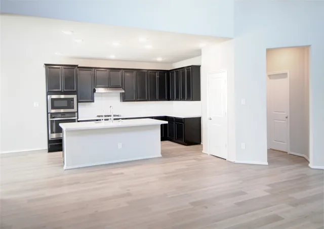 a view of kitchen with stainless steel appliances cabinets and wooden floor