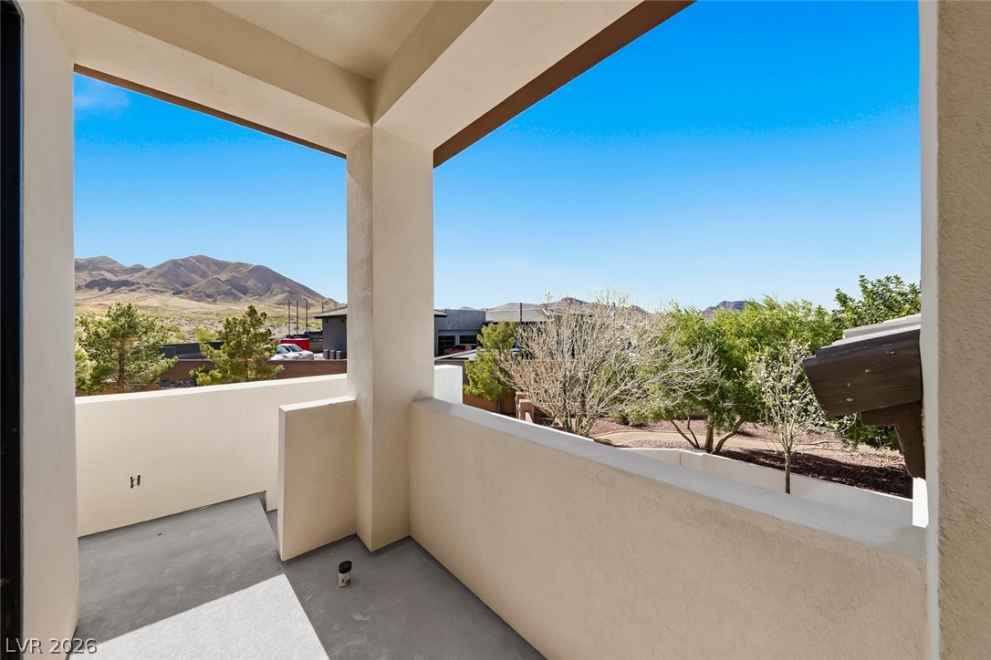 1140 Julie Road Henderson, NV 89002 - Photo 7 of 38 Another private balcony offers serene views of distant mountains and lush greenery.