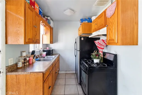 a kitchen with stainless steel appliances a sink window and cabinets