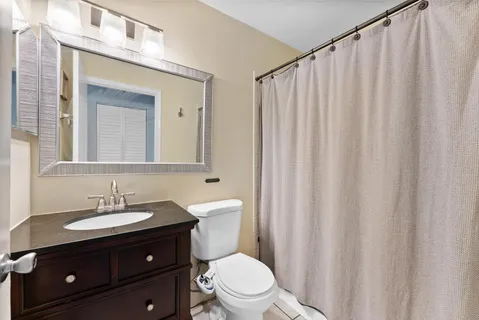 a bathroom with a double vanity sink toilet and a mirror