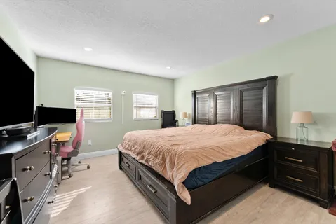 a spacious bedroom with a bed and a dresser in it