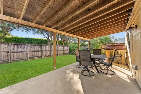 a view of a backyard with table and chairs and wooden fence