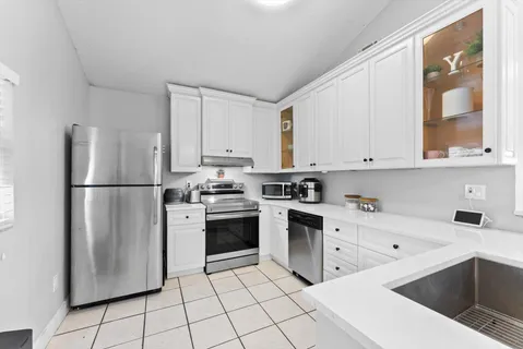 a kitchen with stainless steel appliances granite countertop a refrigerator sink and stove