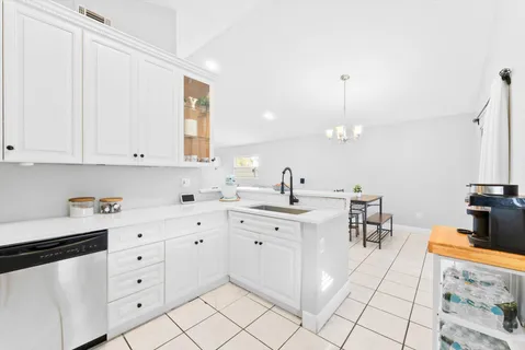 a kitchen with white cabinets and white appliances