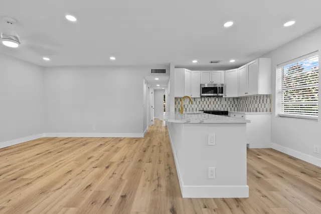 a kitchen with a sink a stove and cabinets