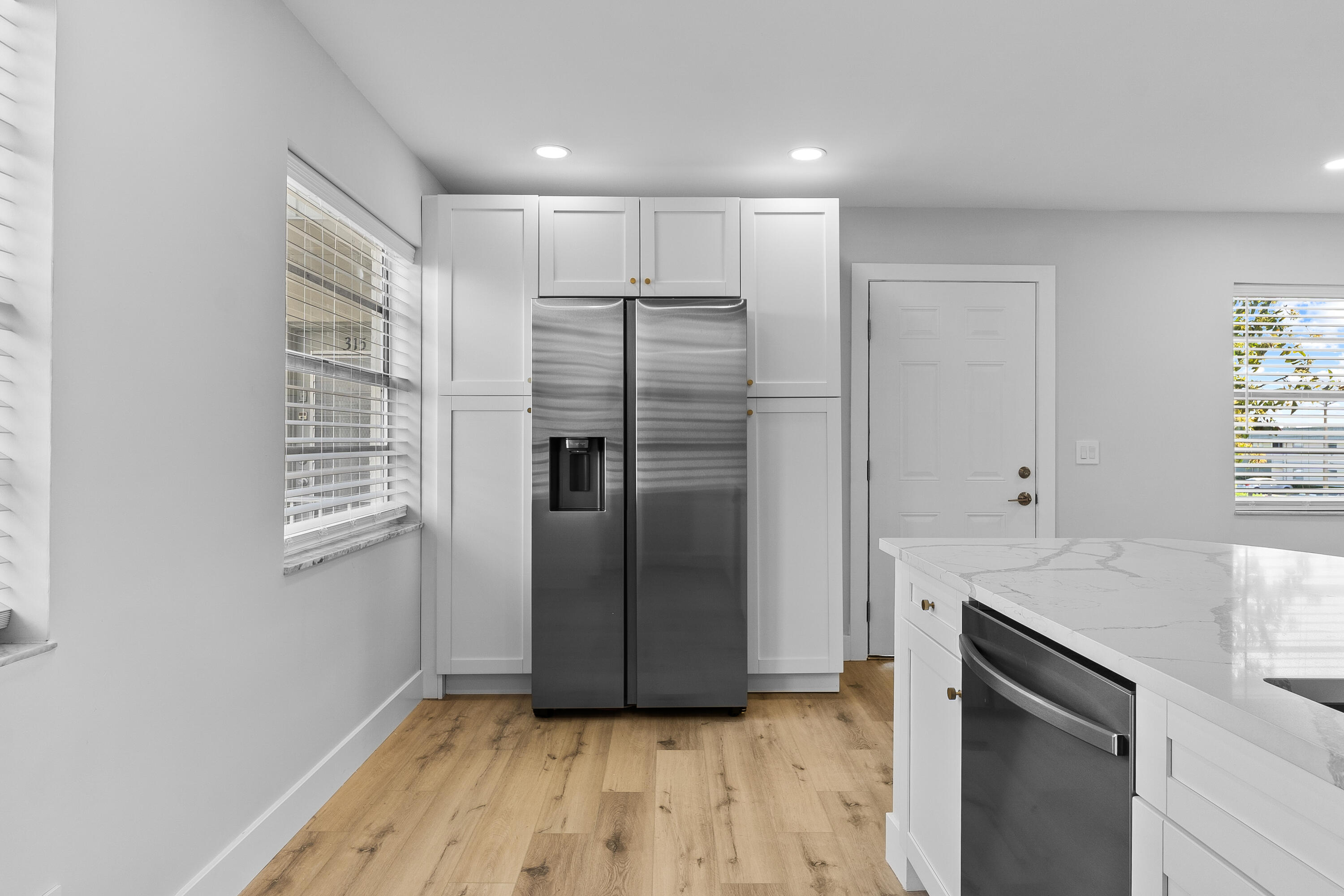 314 Monaco Boulevard, Unit G Delray Beach, FL 33446 - Photo 8 of 26 a view of a refrigerator in kitchen and wooden floor