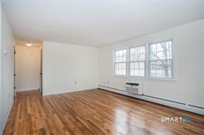 3 Brickyard Road, Unit 17B Farmington, CT 06032 - Photo 4 of 13 an empty room with wooden floor and windows
