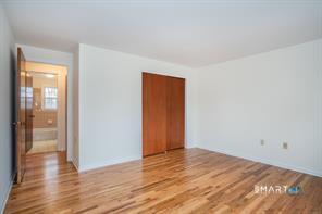 3 Brickyard Road, Unit 17B Farmington, CT 06032 - Photo 8 of 13 a view of an empty room with wooden floor and a window