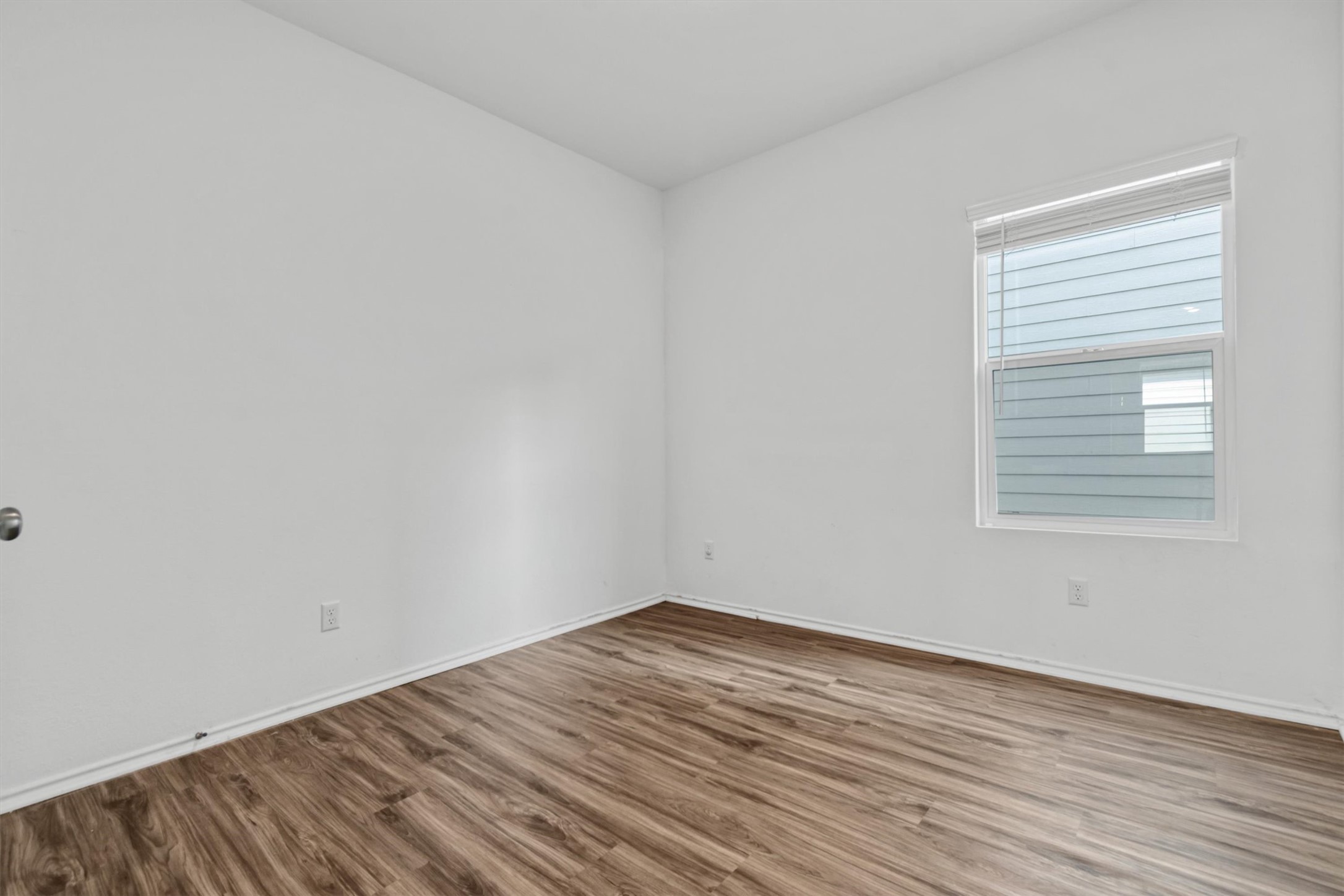 417 Soapstone Pass Maxwell, TX 78656 - Photo 16 of 18 an empty room with wooden floor and windows