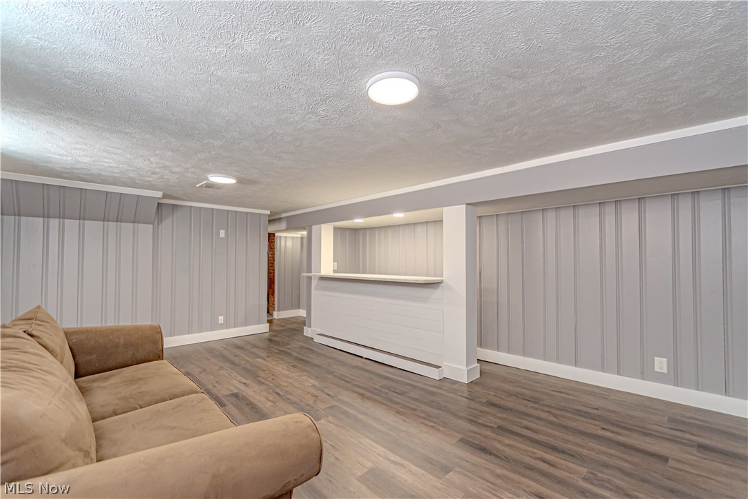 4157 Verona Road Cleveland, OH 44121 - Photo 19 of 26 Living area featuring a textured ceiling, wood finished floors, and a baseboard heating unit