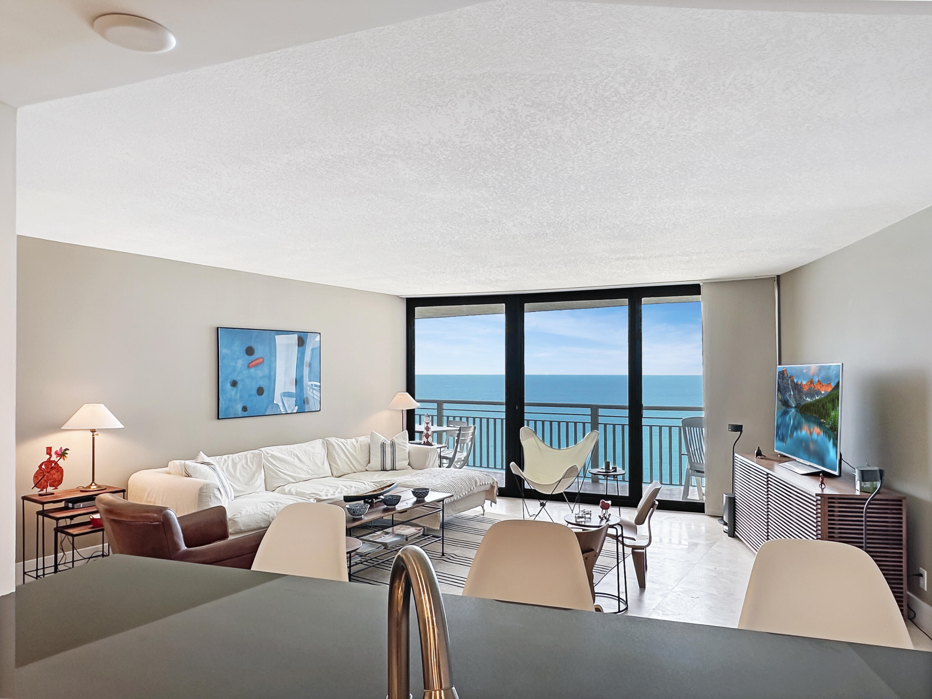 3000 North Ocean Drive, Unit 22D Riviera Beach, FL 33404 - Photo 8 of 53 a living room with furniture large windows and flat screen tv