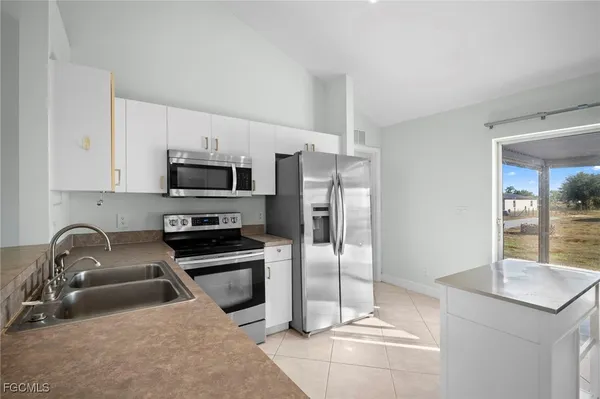 a kitchen with stainless steel appliances granite countertop a sink and a refrigerator
