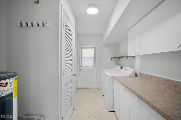 a utility room with cabinets washer and dryer