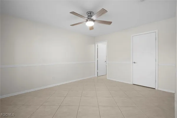 an empty room with closet and ceiling fan