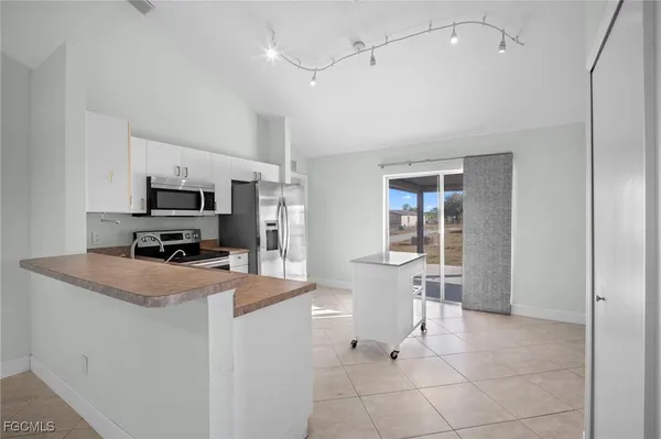 a kitchen view with stainless steel appliances a refrigerator and a stove top oven